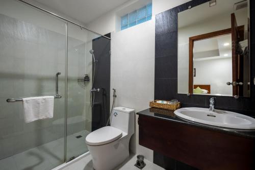 a bathroom with a toilet and a sink and a shower at Skyline Boutique Hotel in Phnom Penh