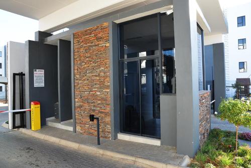 a building with glass doors on the side of it at Eirini Elegant - Hermes Apartment in Midrand