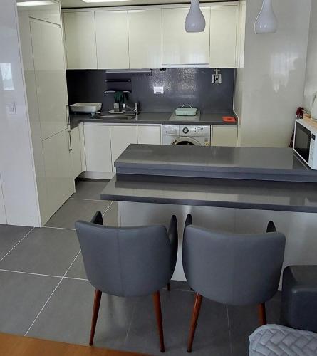 a kitchen with two chairs and a counter top at 바다스테이 in Busan
