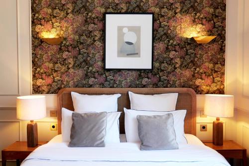 a bedroom with a bed with a picture on the wall at Hôtel Bristol Pau in Pau