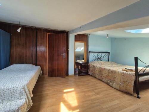 a bedroom with two beds and a wooden floor at Joe's House in Fátima