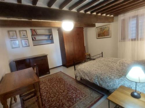 a bedroom with a bed and a table and a desk at Casa alla porta con panorama in Montecastelli Pisano