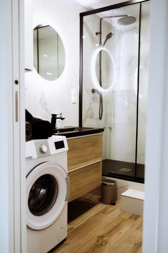 La salle de bains est pourvue d'un lave-linge et d'une douche. dans l'établissement Superbe studio rénové proche Métro avec garage, à Oullins