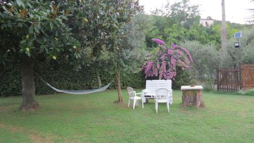 a table and chairs in a yard with a tree at Casa Vacanze “Bouganville” loc Avane Pisa in Vecchiano