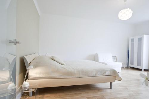une chambre avec un lit dans une pièce blanche dans l'établissement Vienna Central Apartment Siebenbrunnen, à Vienne