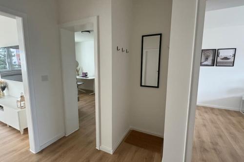 a white room with a mirror and a hallway at Cozy apartment with balcony in Lehre