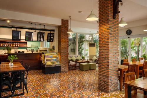a restaurant with tables and chairs and a brick pillar at Skyline Boutique Hotel in Phnom Penh