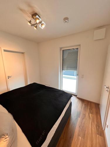 a bedroom with a large bed and a window at Modernes City-Apartment - Top-Lage in Nürnberg in Nürnberg