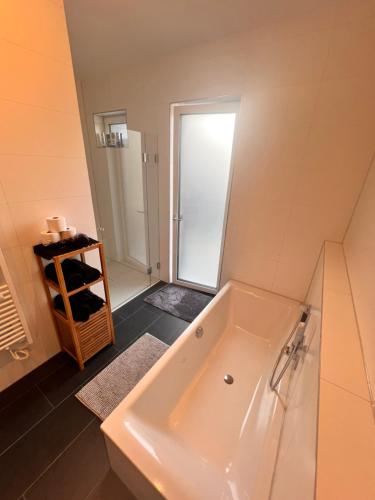 a bathroom with a tub and a walk in shower at Modernes City-Apartment - Top-Lage in Nürnberg in Nürnberg