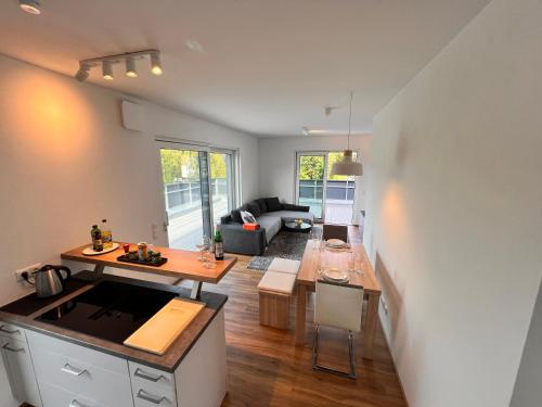 a kitchen and living room with a table and a counter top at Modernes City-Apartment - Top-Lage in Nürnberg in Nürnberg