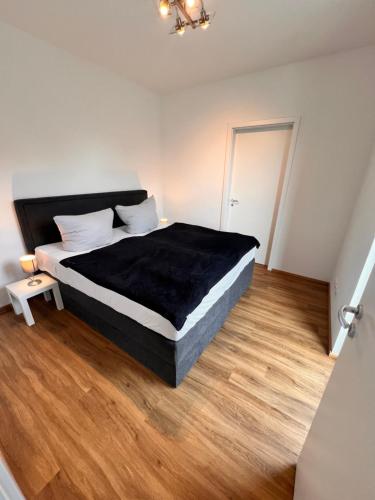 a bedroom with a large bed with a black blanket at Modernes City-Apartment - Top-Lage in Nürnberg in Nürnberg