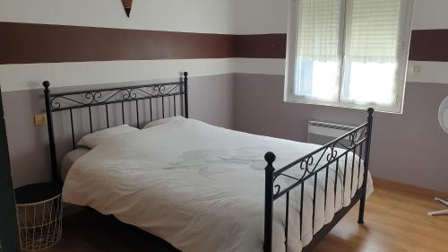 una camera da letto con un letto con lenzuola bianche e una finestra di Orteils au soleil jardin parking a Nîmes