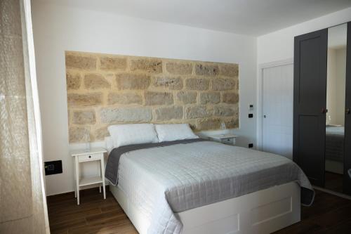 a bedroom with a bed and a stone wall at Villa Albamonte in Carini