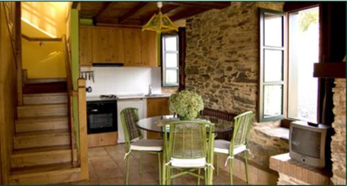 eine Küche mit einem Tisch und Stühlen sowie eine Küche mit einer Theke in der Unterkunft Casa do Cura in Beigondo