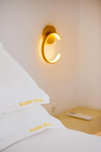 a gold light on a wall next to a bed at Eutixia Houses - Complex of 3 deluxe studios in Vóthon