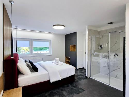a bedroom with a white bed and a shower at Salón MISSEN in Trenčianske Teplice