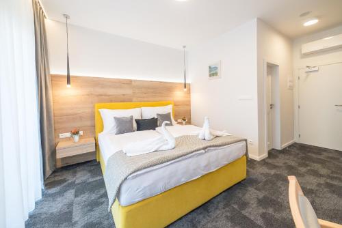 a bedroom with a large bed with a yellow headboard at Salón MISSEN in Trenčianske Teplice