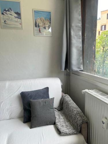 - un canapé blanc dans une pièce avec fenêtre dans l'établissement Studio à Pra loup, à Pra-Loup
