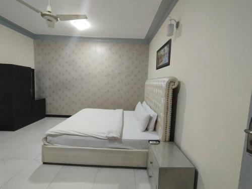Un dormitorio con una cama y una mesa dentro. en Travel Inn islamabad, en Islamabad