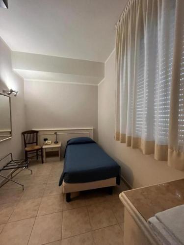 a bedroom with a bed and a table and a window at Hotel Classicano in Ravenna