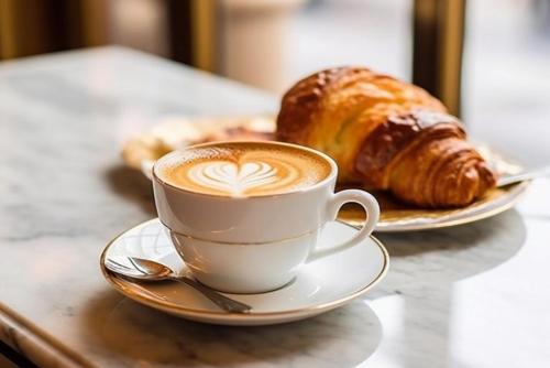 een kopje koffie en croissants op een tafel bij Alis Laura Guest House - Near Metro Bologna, Easy Access to All Rome in Rome