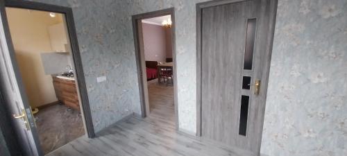 an empty room with a door and a kitchen at Qonaq evi quest home in Sheki