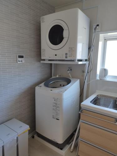 a washer and dryer in a kitchen next to a sink at Breath of the Sea Katakai in Katakai