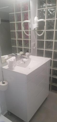 a white bathroom with a sink and a mirror at La Muralla Roja in Calpe