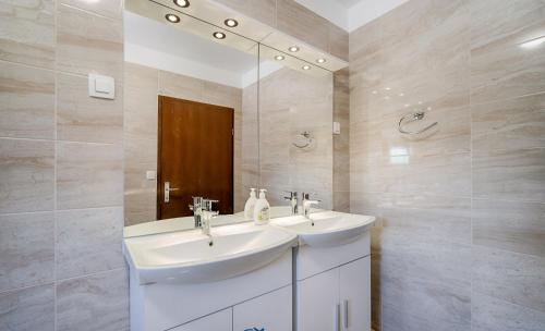 a bathroom with two sinks and a mirror at New villa with pool, 600 m from the beach - by TRAVELER tourist agency Krk ID 2164 in Pinezici