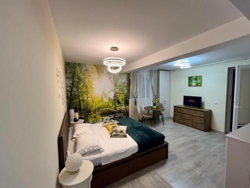 a bedroom with a large bed with a painting on the wall at Confort Studio in Alba Iulia