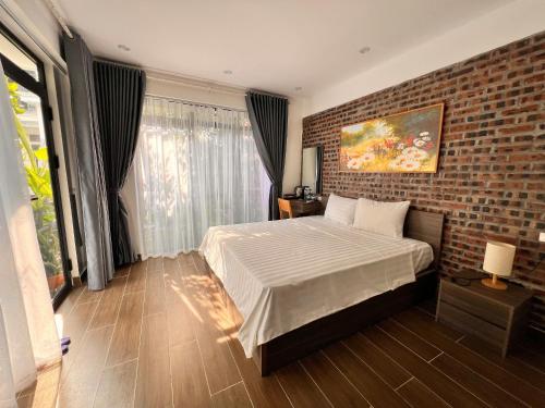 a bedroom with a bed and a brick wall at Tam Coc Boutique Garden in Ninh Binh