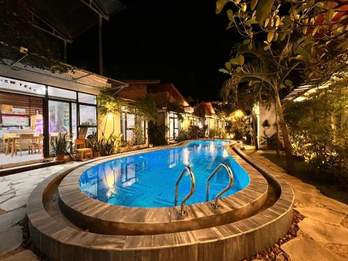 a swimming pool at night with two swans in it at Tam Coc Boutique Garden in Ninh Binh