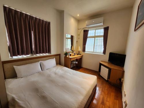 a bedroom with a bed and a desk and windows at 日月潭全家湖畔民宿-包棟烤肉釣魚九族纜車遊湖sup優惠票券 in Yuchi