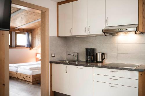 a kitchen with a sink and a bed in a room at Christophorus Mountain Residence in San Vigilio Di Marebbe