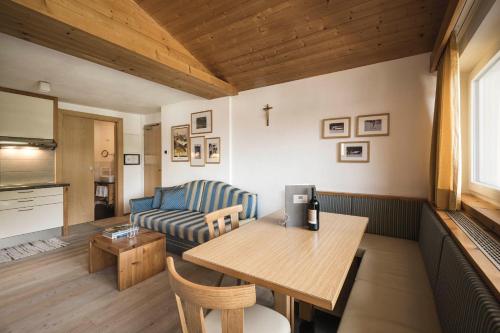 a living room with a table and a couch at Christophorus Mountain Residence in San Vigilio Di Marebbe