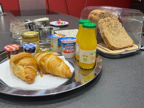 une table garnie de croissants et de pain sur une table dans l'établissement Chambre marais, à Écourt-Saint-Quentin