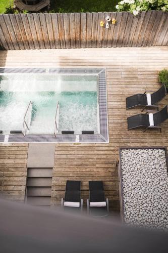 an overhead view of a swimming pool with two chairs and a swimming pool at Christophorus Mountain Residence in San Vigilio Di Marebbe