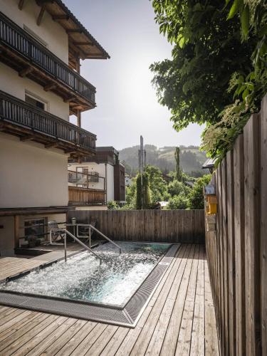 a swimming pool in a backyard with a wooden deck at Christophorus Mountain Residence in San Vigilio Di Marebbe