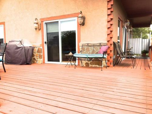 a wooden deck with chairs and a sliding glass door at RUSTIC ARMADILLO CABIN with VIEW BY HIDDEN FALL PARK, Fenced yard for Dogs in Smithwick