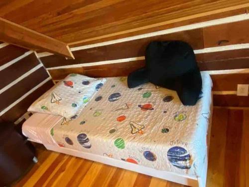 a bed in a tiny house with a bedsheet at RUSTIC ARMADILLO CABIN with VIEW BY HIDDEN FALL PARK, Fenced yard for Dogs in Smithwick