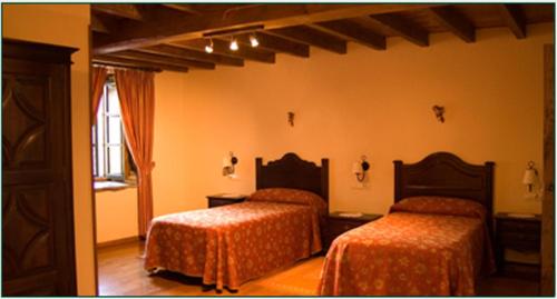 1 dormitorio con 2 camas y ventana en Casa do Cura, en Beigondo