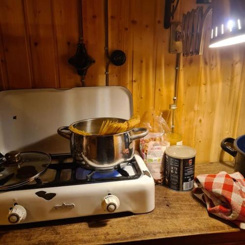 a pot on top of a stove in a kitchen at Schäferwagen mit Dachterrasse an der Pferdekoppel in Haus im Wald