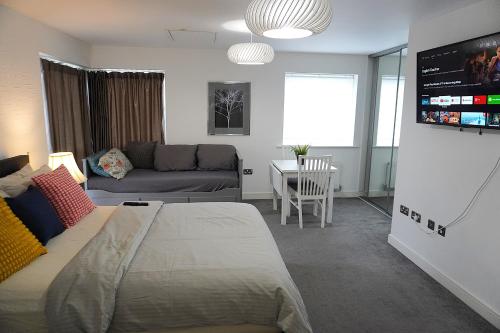a bedroom with a bed and a living room with a couch at Rylance Luxury House - Free Parking in Manchester