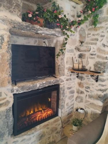 a stone fireplace with a television on top of it at ΜΕΣΤΑ - ΠΛΑΤΕΙΑ in Mesta