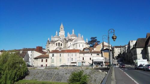 un grand bâtiment blanc avec des tours dans une rue de la ville dans l'établissement Studio Périgueux, à Périgueux