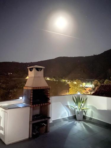 a rooftop with a brick oven on a balcony at night at Alquiler rural Cútar, Casa Robles (en la Axarquía) in Cútar