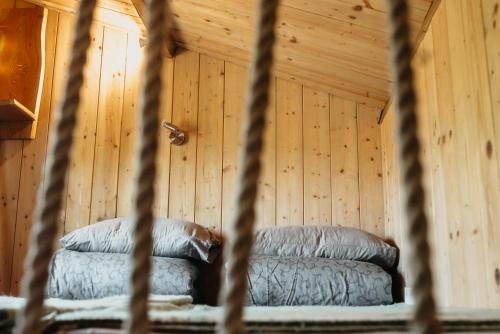 a bed in a room with a wooden wall at Beneháti kunyhók in Matrafured