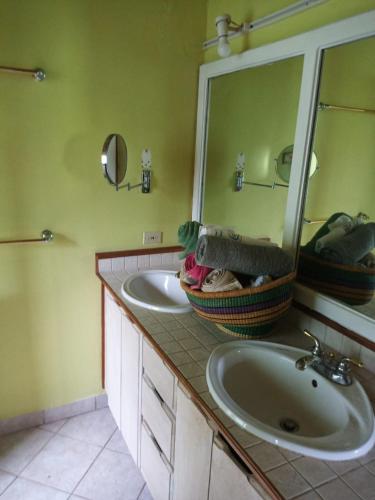 a bathroom with two sinks and a large mirror at Paradise Point Villas in Castara