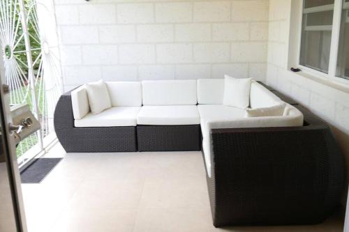 a white couch in a room with a window at Golden Acre Beach Villa-2 mins walk - Alleynes Bay in Saint James