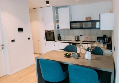 a kitchen with a table and blue chairs at LuxDS in Tuzla